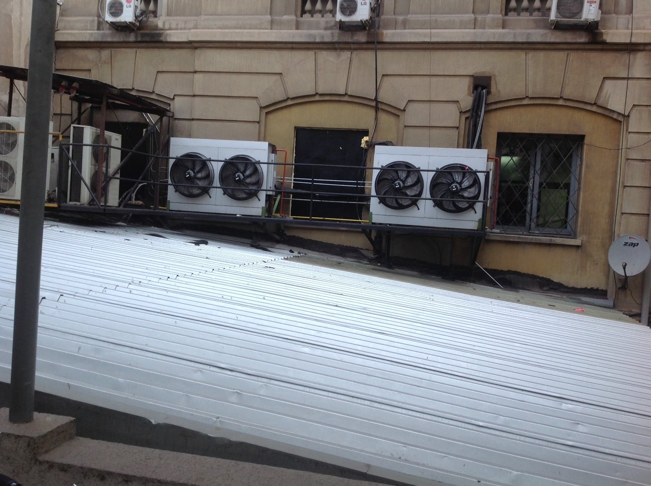 Unidades condensadoras de climatización instaladas sobre plataforma en fachada exterior del edificio