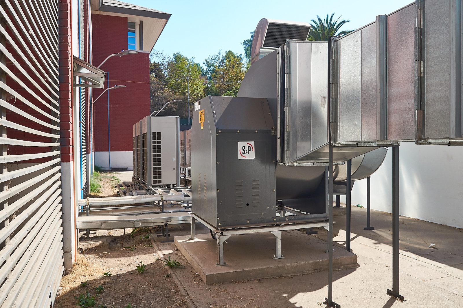 Ventilador centrífugo de inyección de aire con ductos galvanizados junto a condensadoras VRF